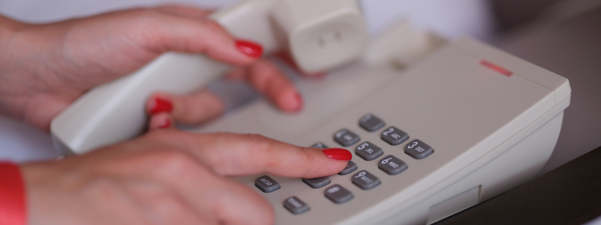 female hands with red manicure dialing 811 closeup